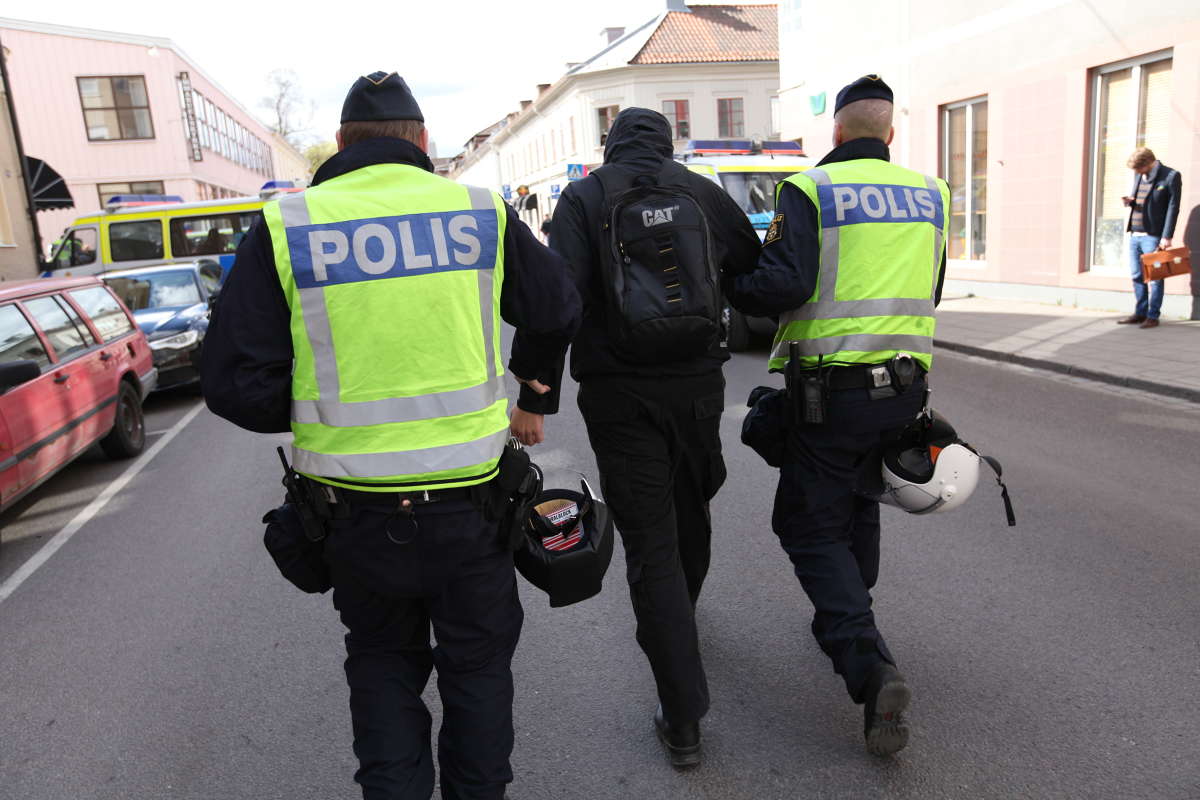 En motdemonstrant leds iväg. En motdemonstrant leds iväg.